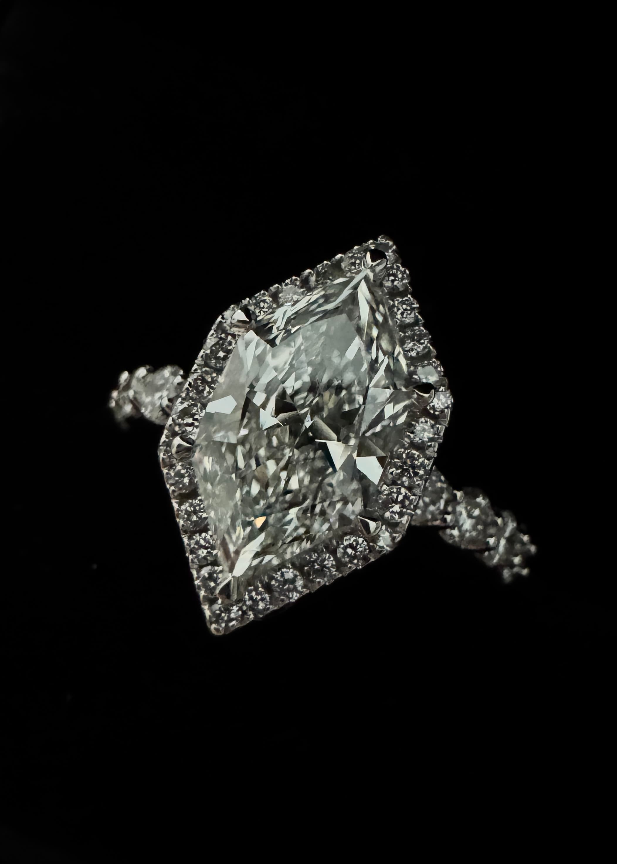 Dutch
Marquis engagement ring with marquise-cut diamond halo on black background